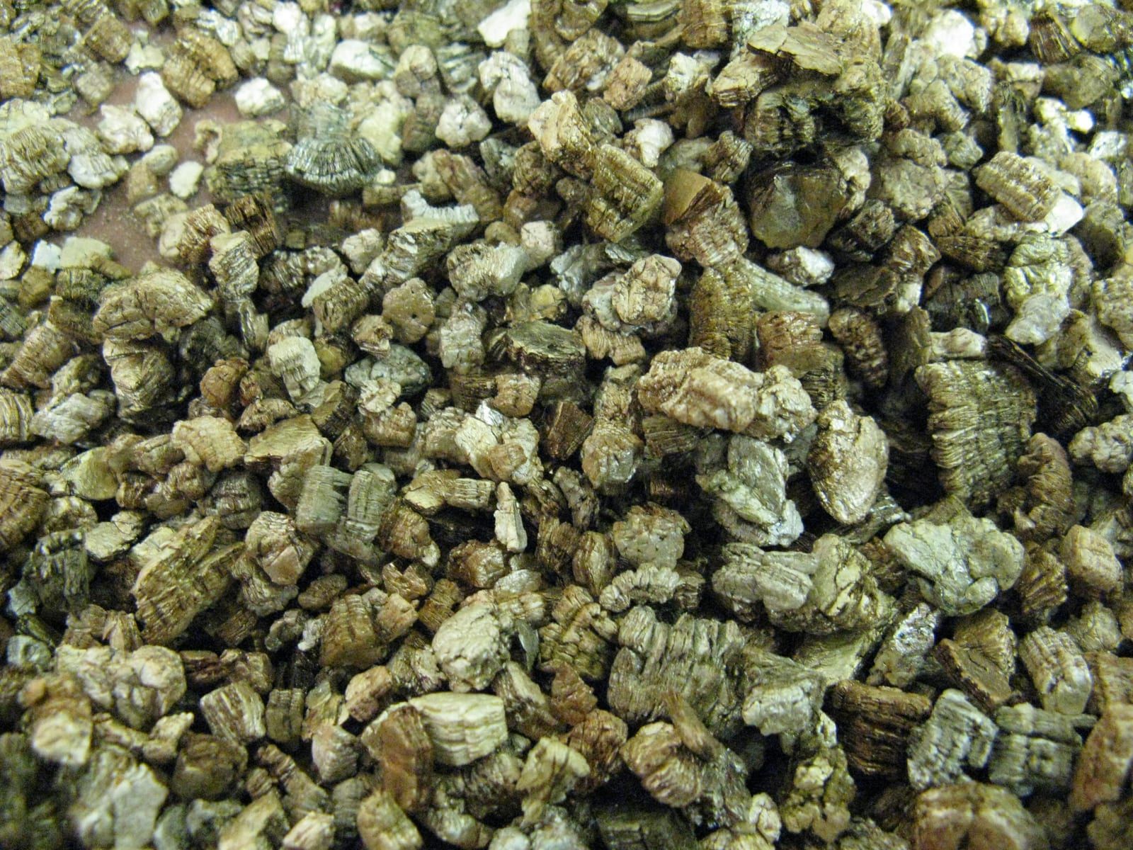 Gold-brown expanded vermiculite flakes, horticultural grade, filling the frame.